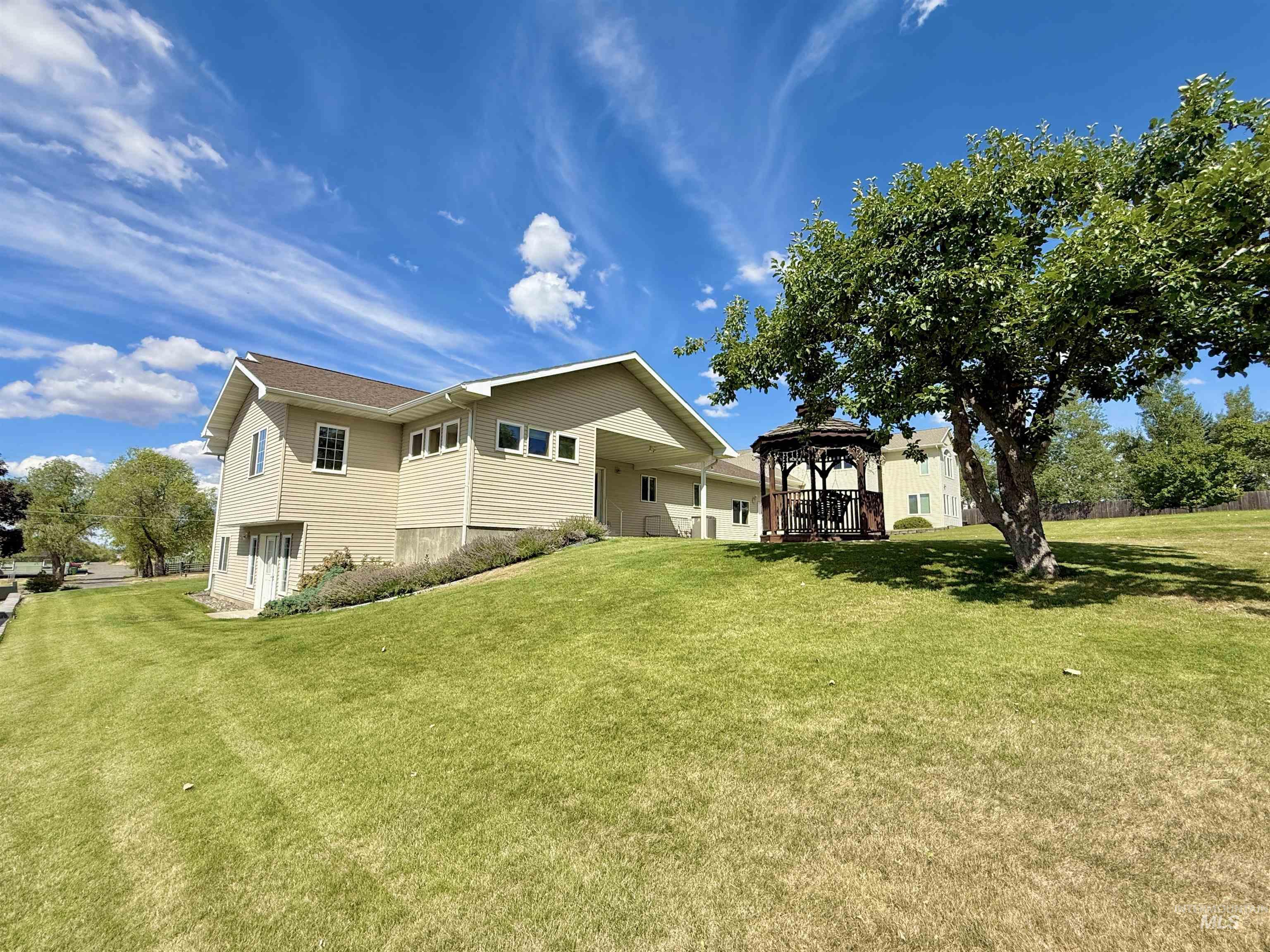 View of home's exterior with a gazebo and a yard