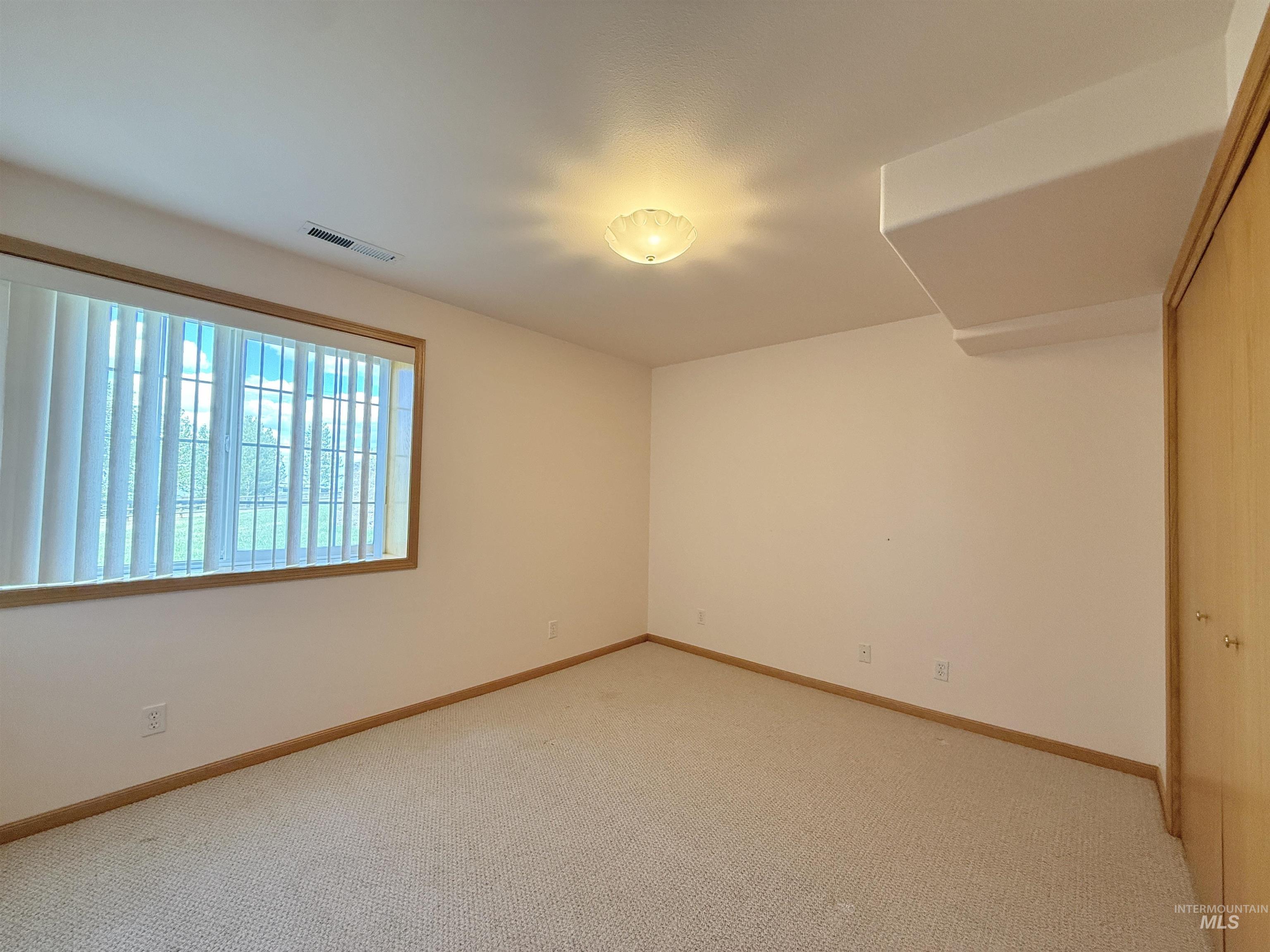 Unfurnished room featuring light carpet
