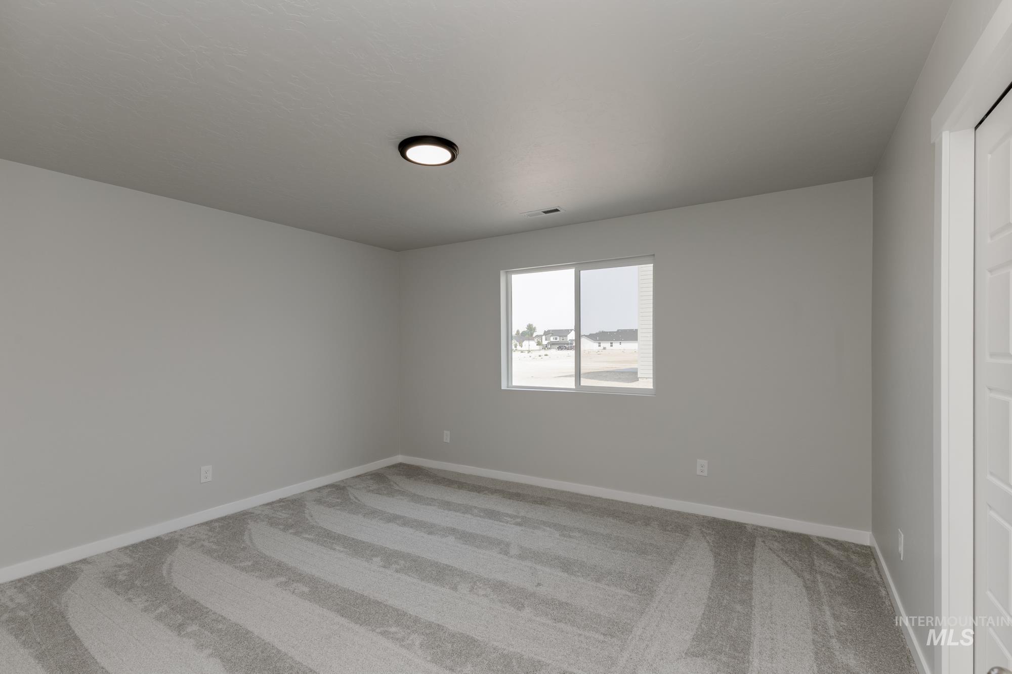 Unfurnished room with light colored carpet and baseboards