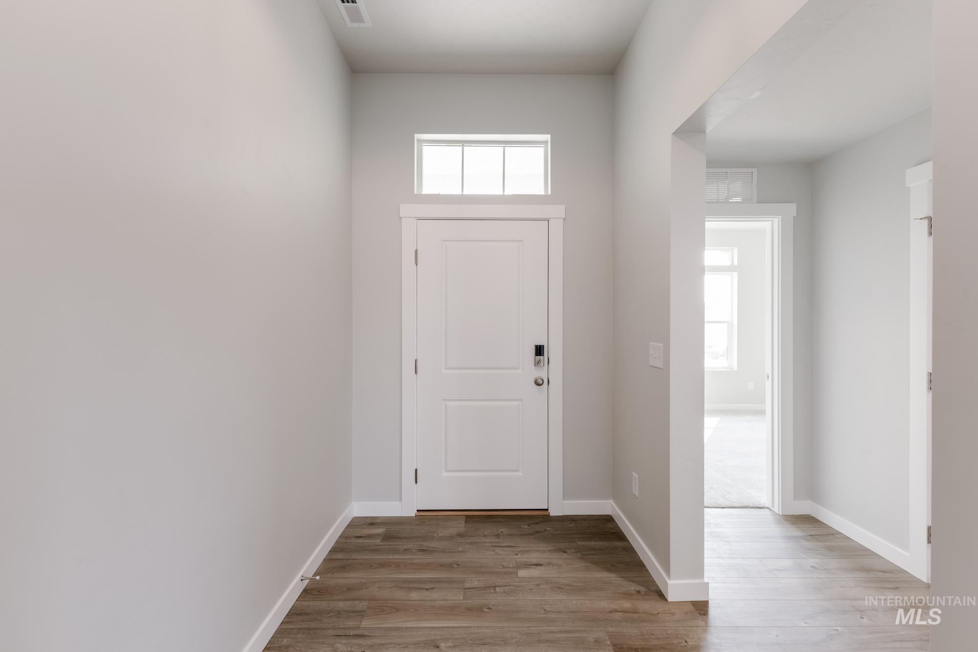 Foyer featuring light wood-style flooring and baseboards