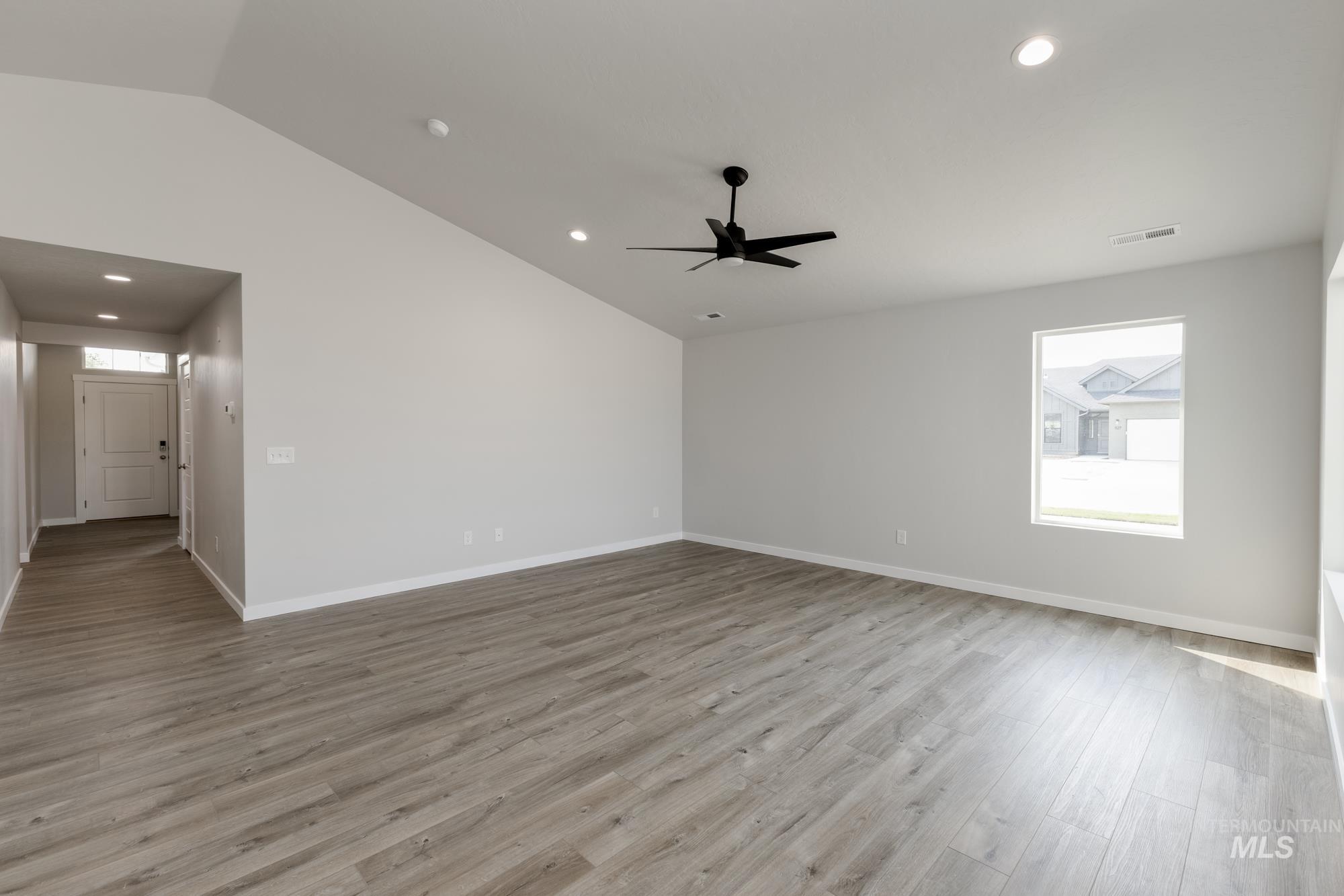 Unfurnished living room with light wood-style flooring, recessed lighting, and lofted ceiling