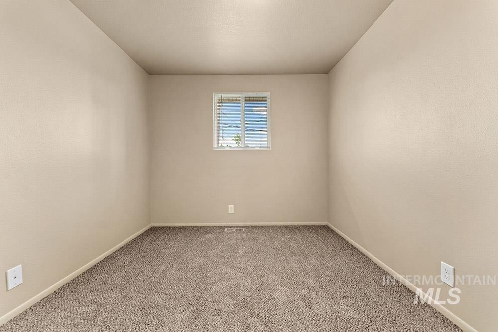 Carpeted empty room featuring baseboards
