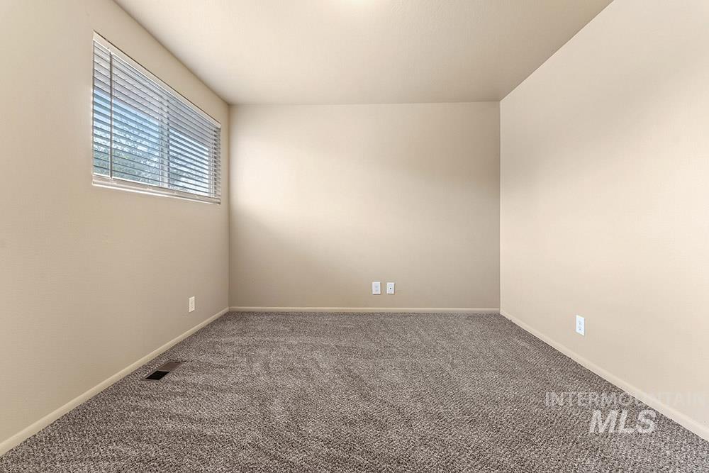 Carpeted empty room with baseboards