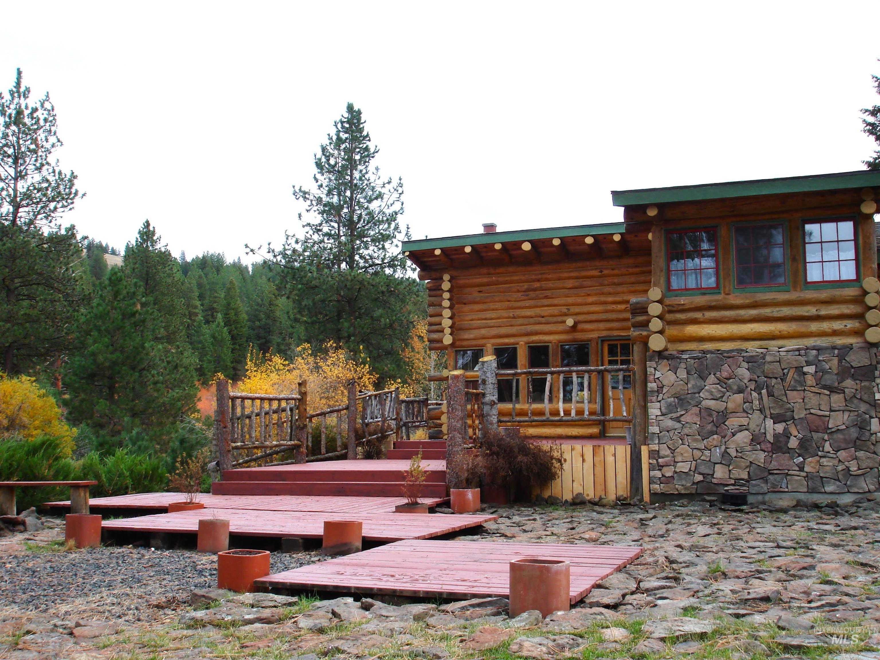 Back of house with log exterior and a deck