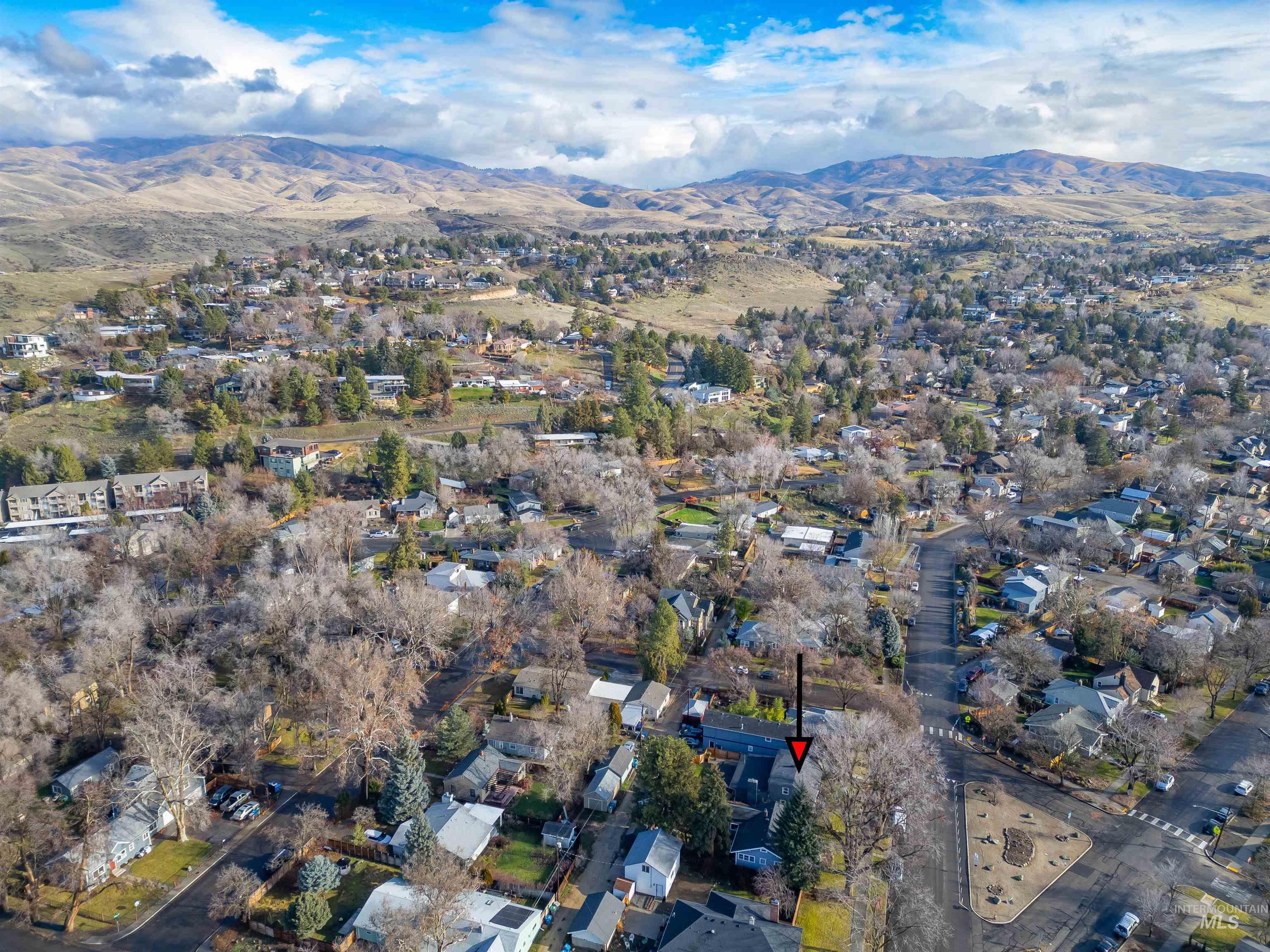 Aerial view of property's location with a mountain backdrop and nearby suburban area