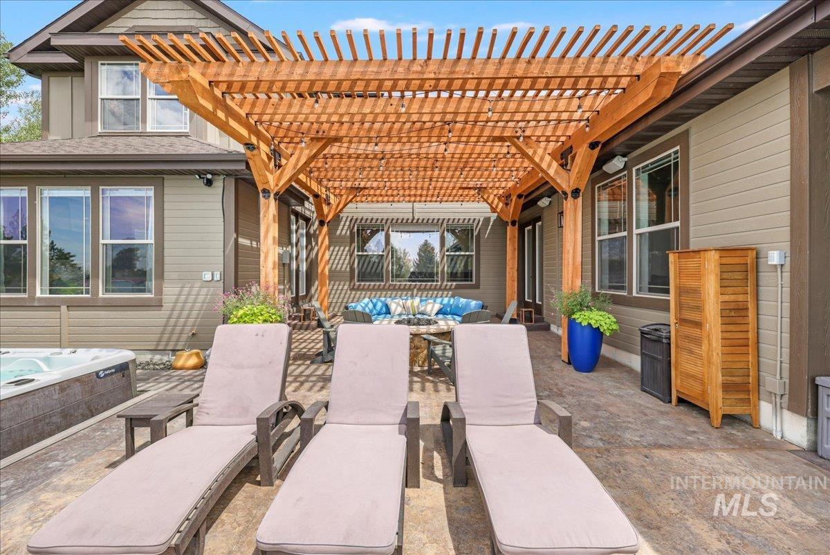 View of patio / terrace featuring a pergola, a hot tub, and outdoor lounge area