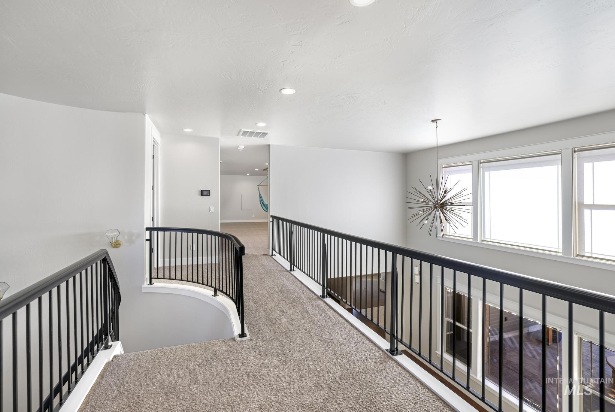 Hallway with carpet and a chandelier