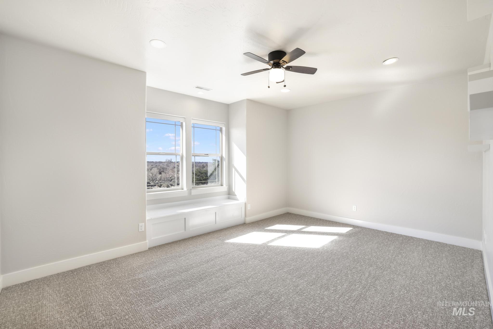 Carpeted empty room featuring a ceiling fan and recessed lighting