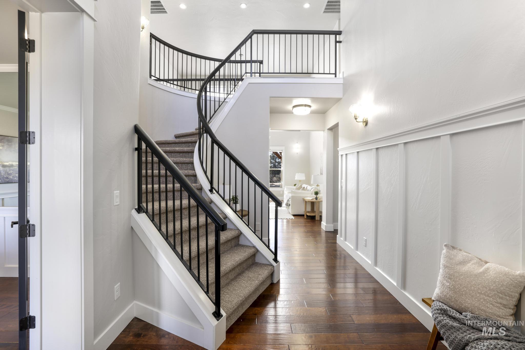 Staircase featuring hardwood / wood-style flooring and a high ceiling