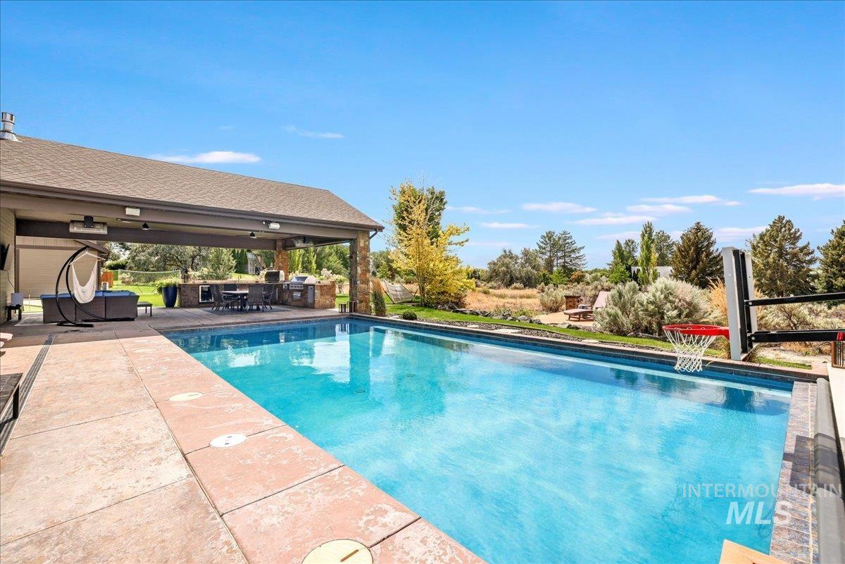 Swimming pool with a patio and area for grilling