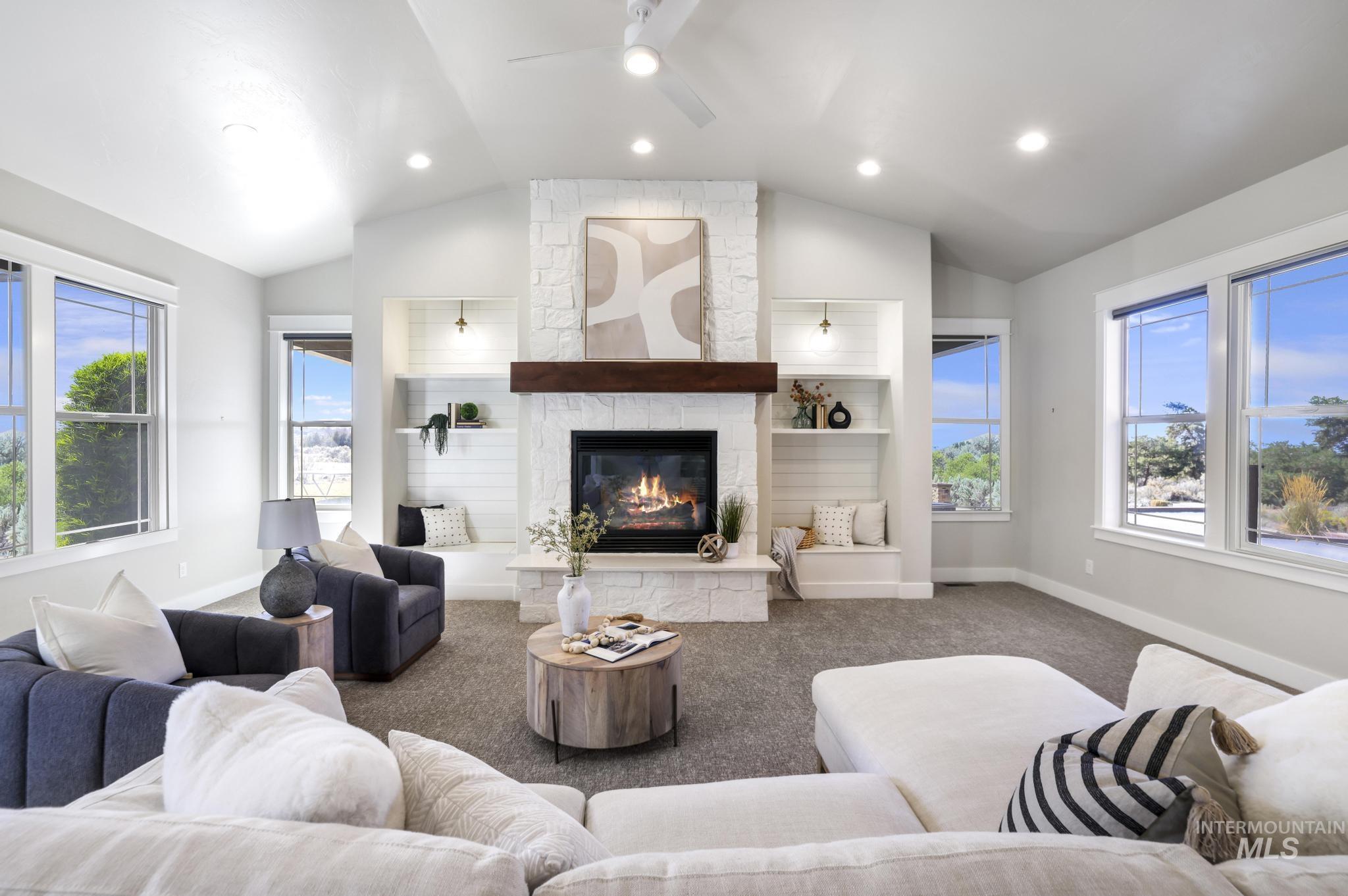 Living area featuring ceiling fan, a stone fireplace, carpet floors, recessed lighting, and vaulted ceiling