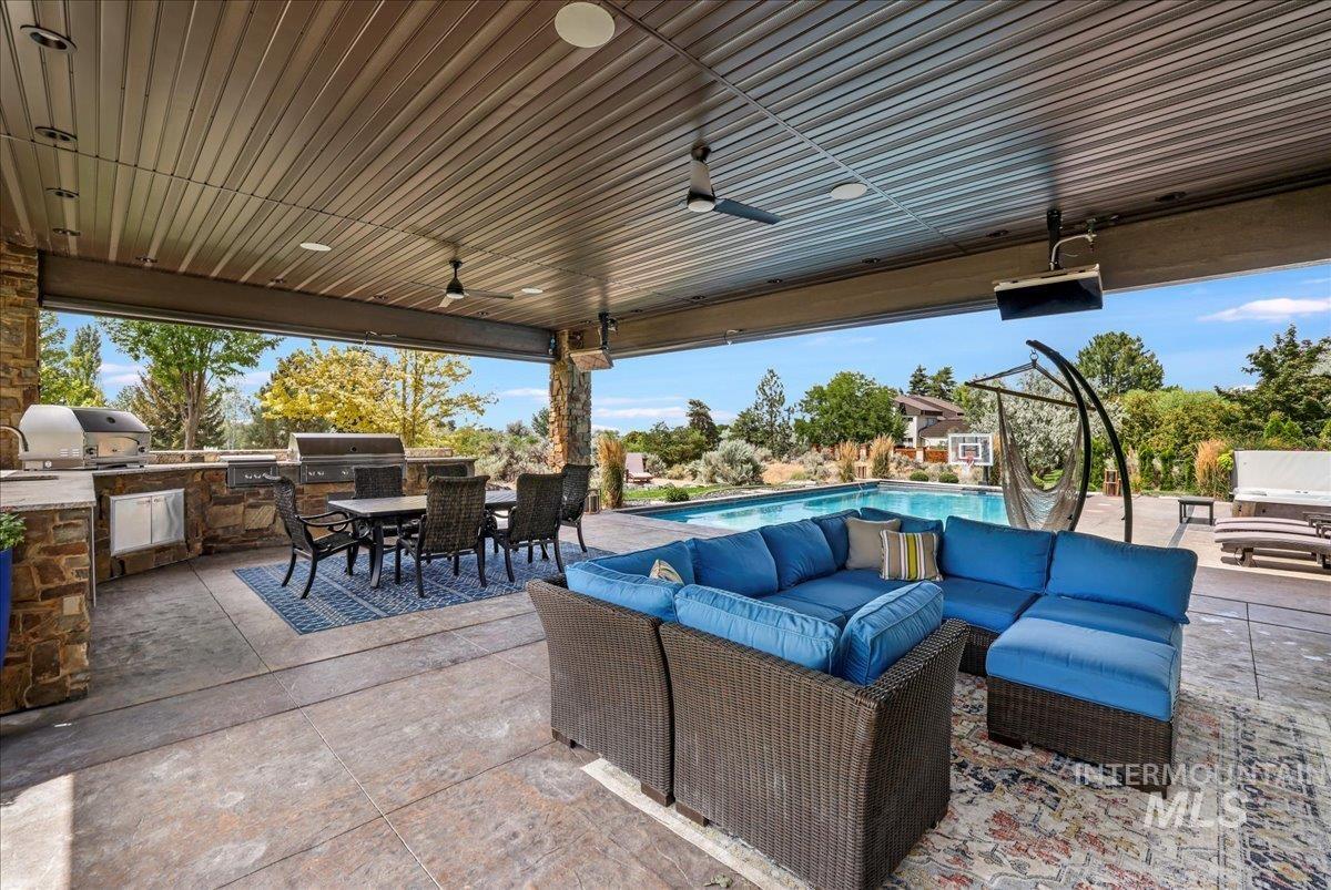 View of patio featuring area for grilling, outdoor dining space, an outdoor living space, and a ceiling fan