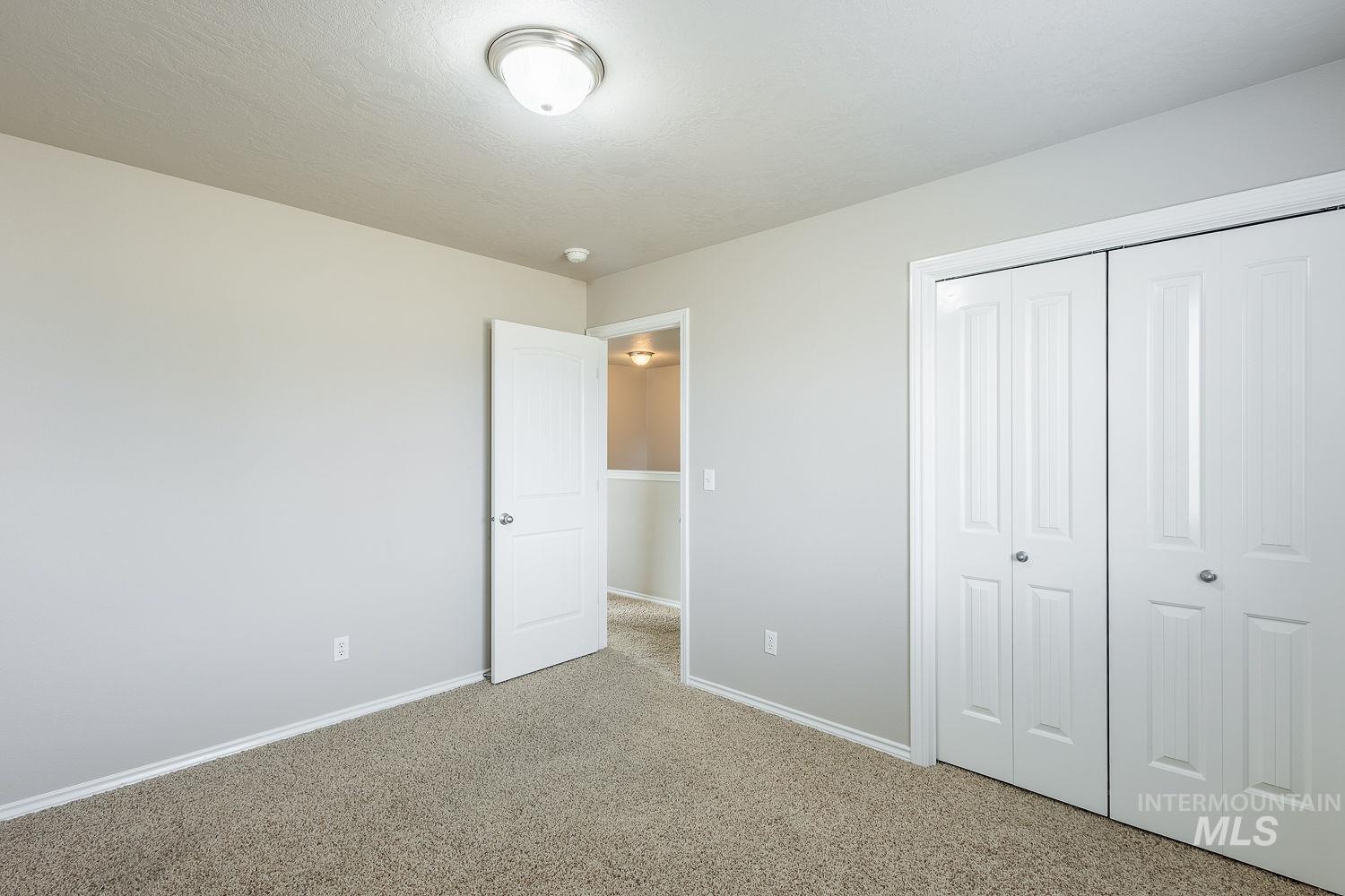 Unfurnished bedroom with carpet floors, a closet, and a textured ceiling