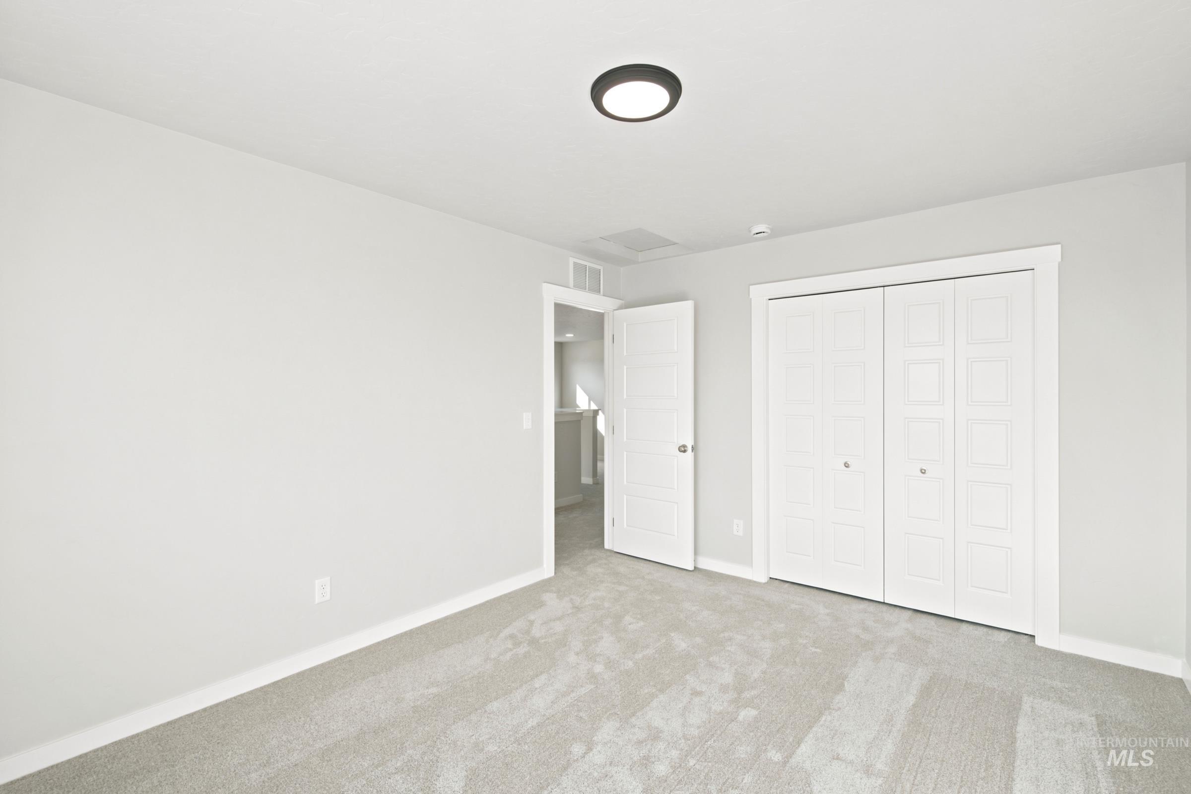 Neutral-toned room featuring light gray walls, plush gray carpeting, and white trim