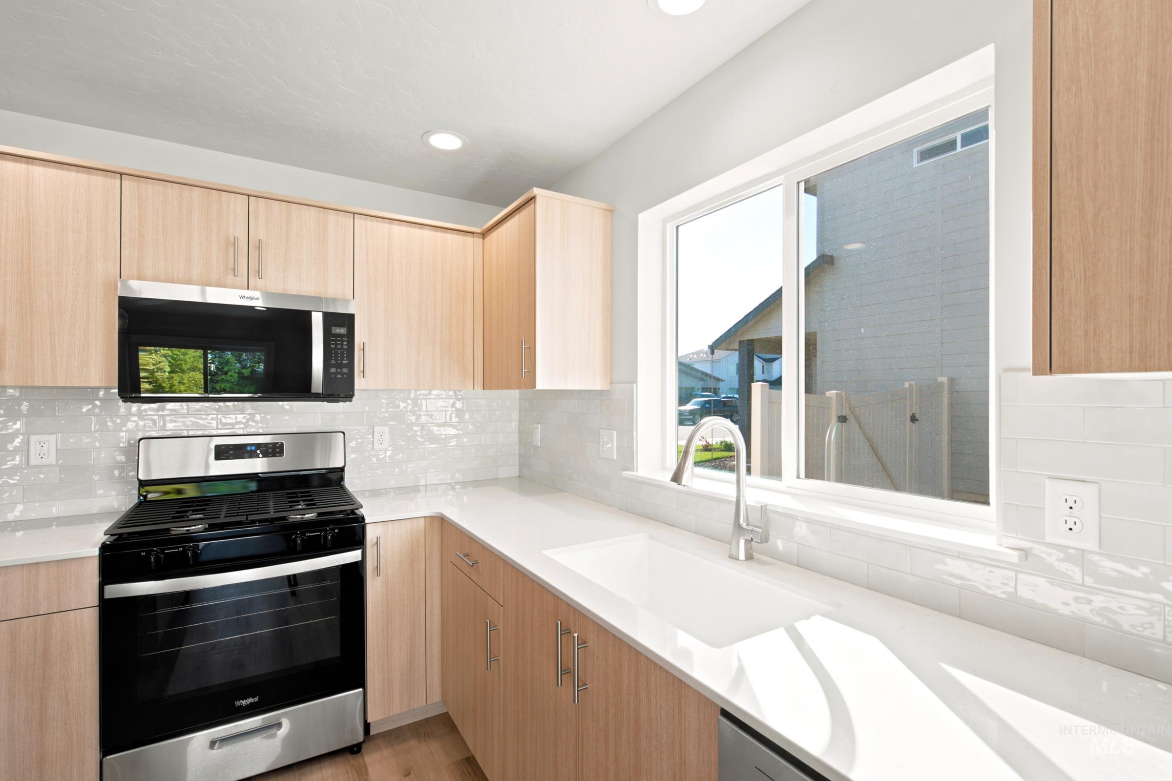 Light wood-finish cabinetry complemented by white countertops and a tiled backsplash