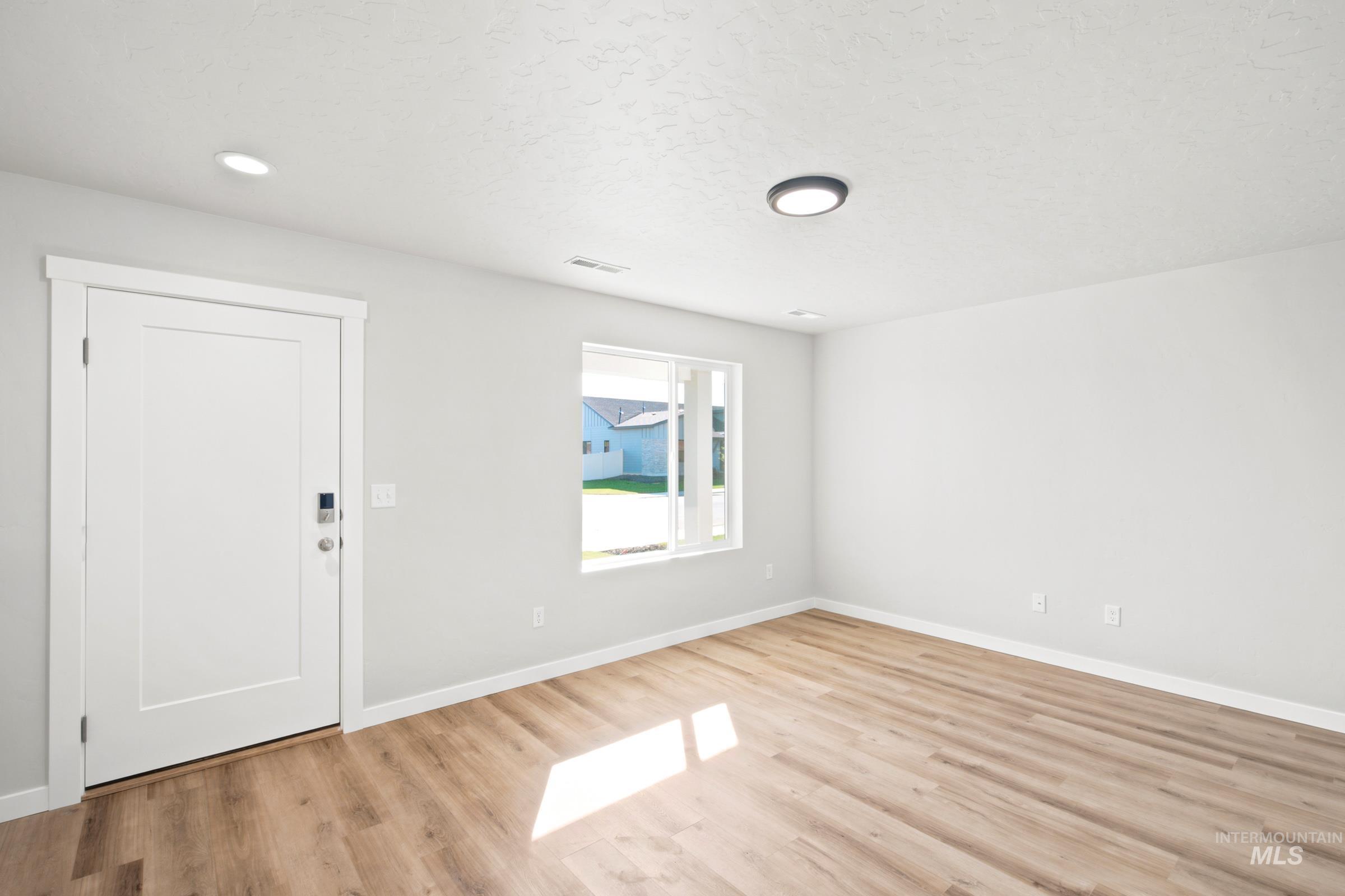 Bright interior space featuring wood-finish flooring, recessed lighting, and a modern ceiling fixture