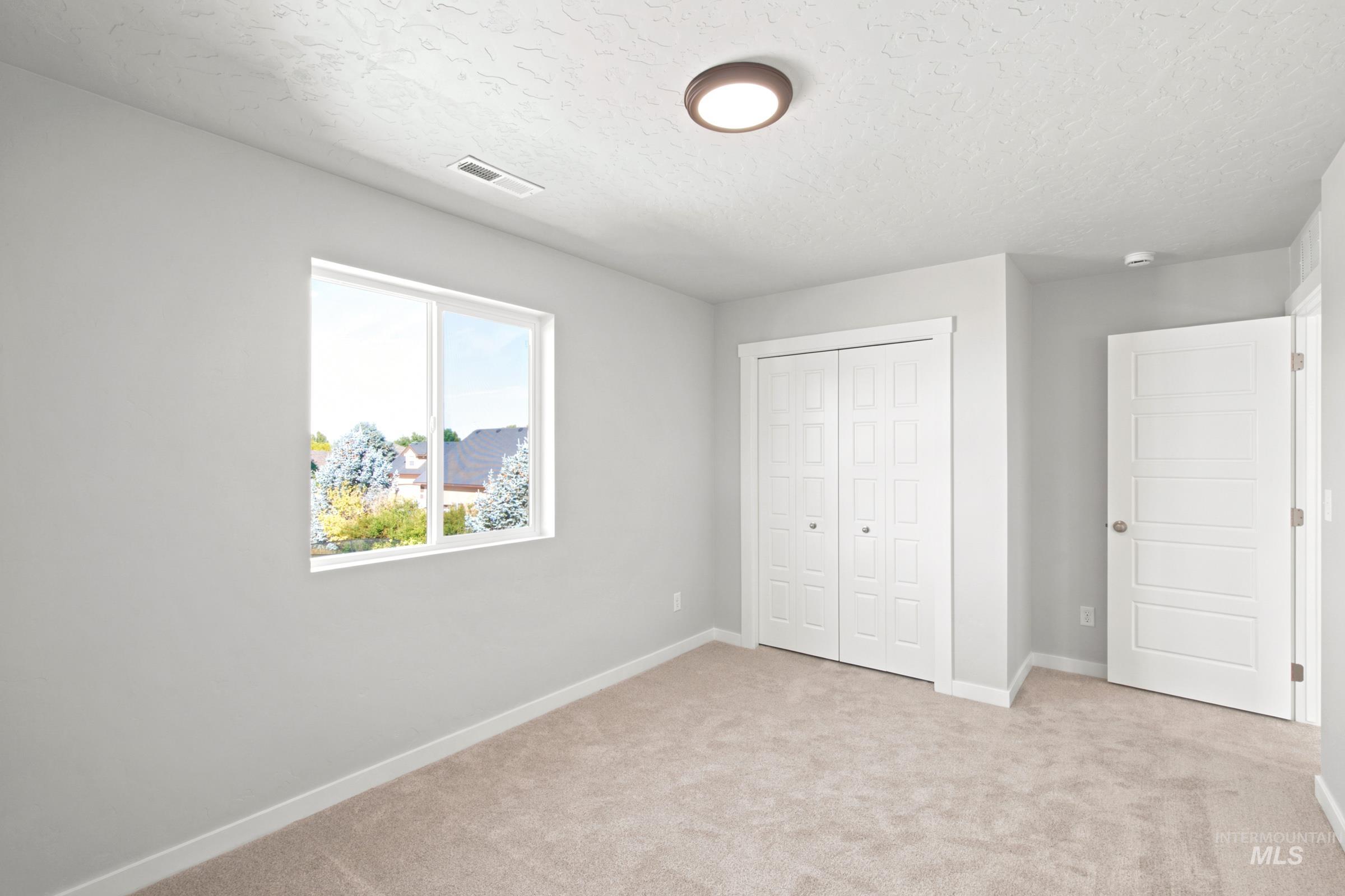 Carpeted interior space with a window offering exterior scenery