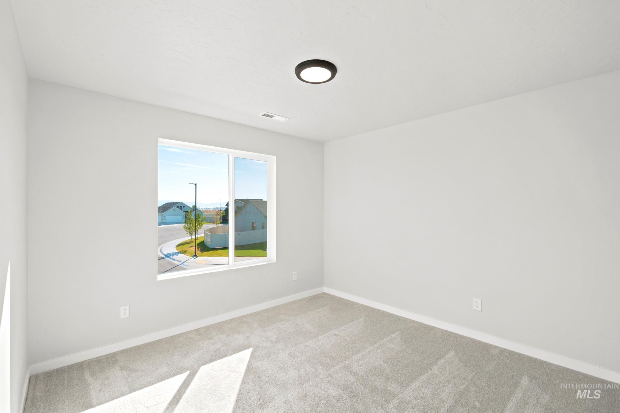 Room featuring light gray carpeting, neutral wall color, and a modern flush-mount ceiling light