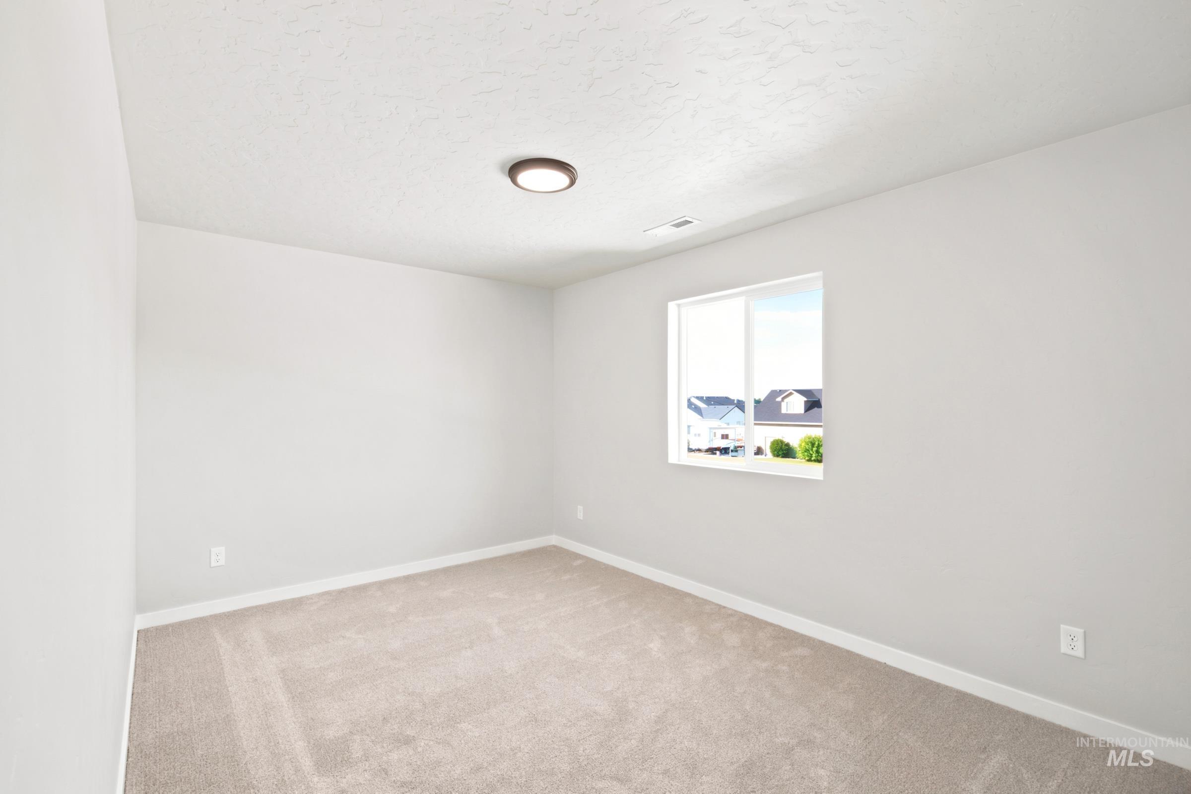 Neutral-toned room with plush carpet flooring, white baseboards, and light gray walls