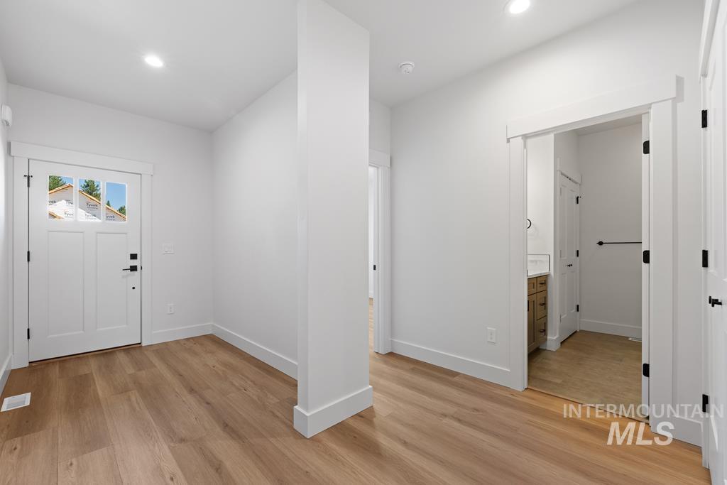 Foyer with light wood-style floors and recessed lighting