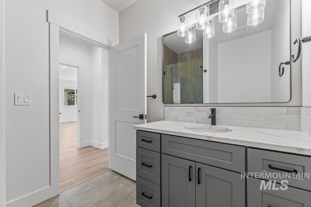 Full bath featuring a stall shower and vanity