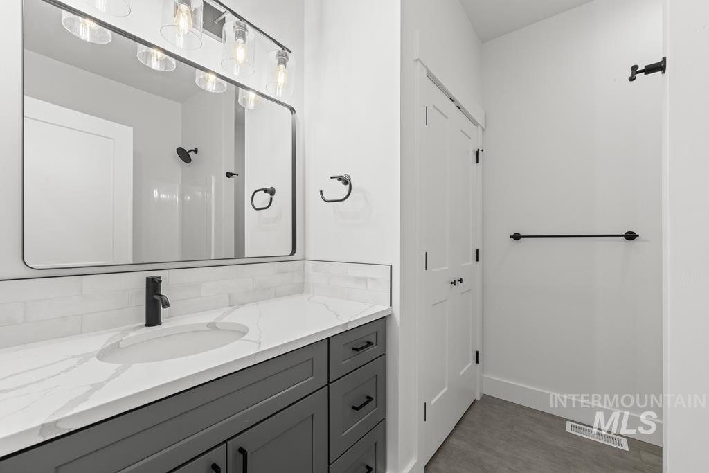 Full bath featuring vanity and baseboards