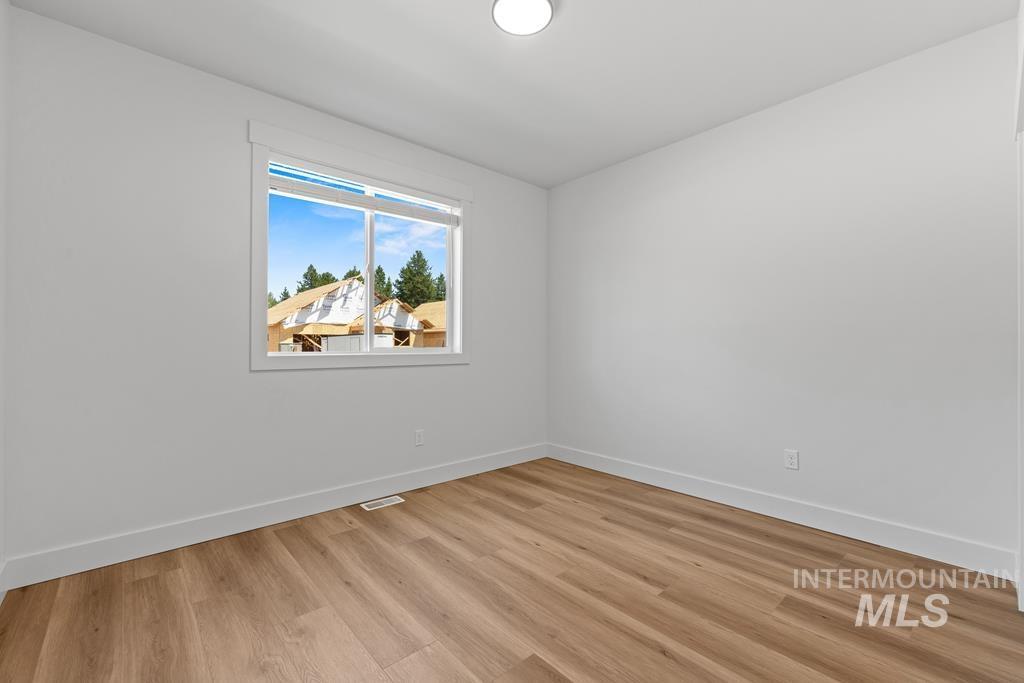 Unfurnished room with light wood-type flooring and baseboards