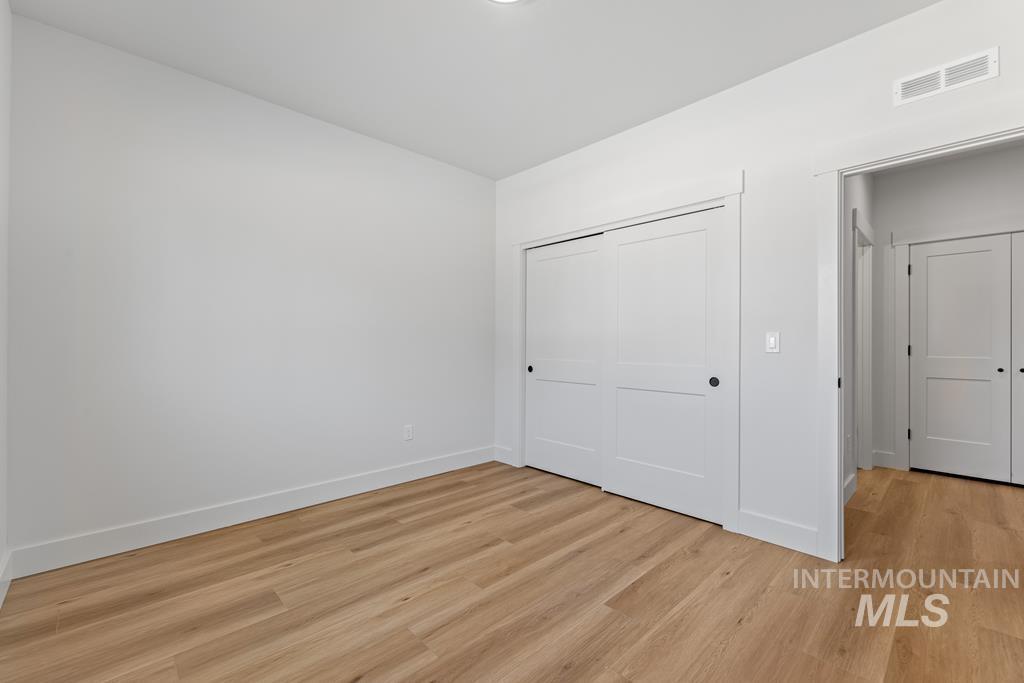 Unfurnished bedroom featuring light wood-type flooring and a closet
