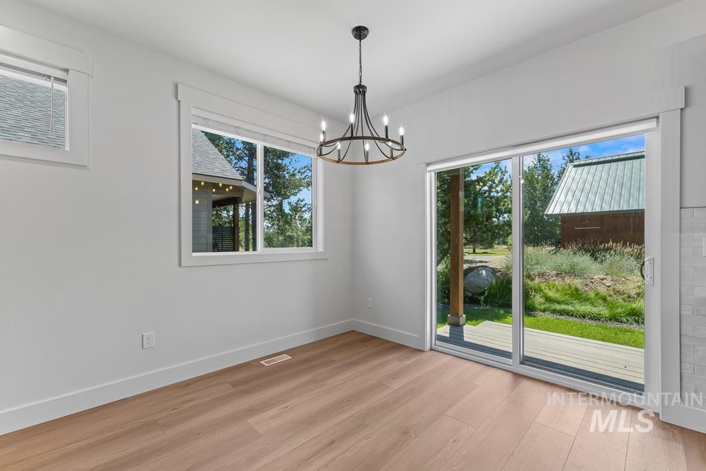 Unfurnished dining area featuring a chandelier and light wood finished floors