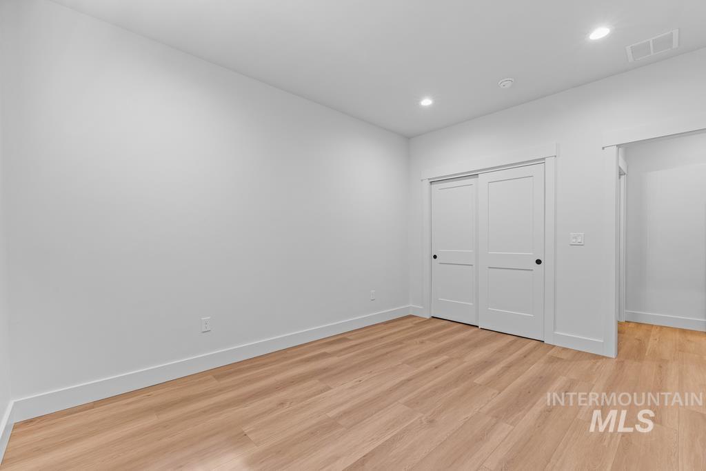 Unfurnished bedroom with light wood finished floors, recessed lighting, and a closet