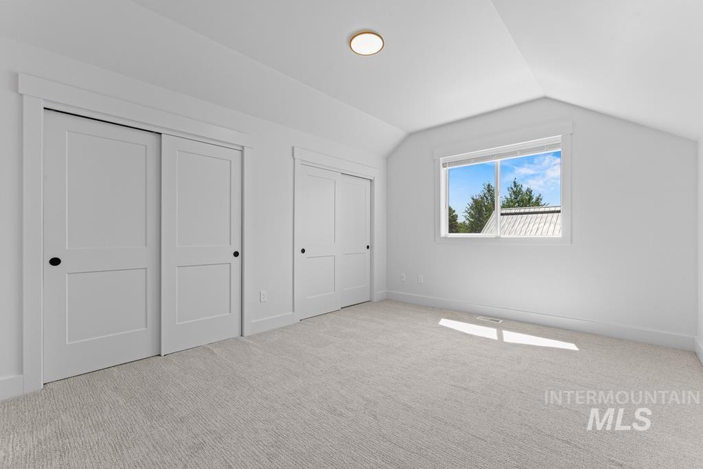 Bonus room featuring lofted ceiling and light carpet