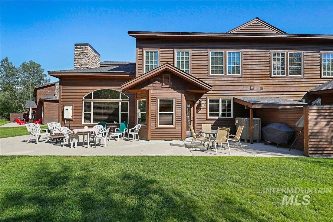 Back of home with a yard and a patio