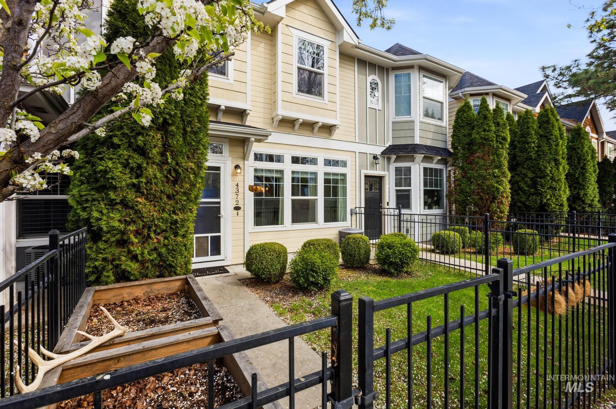 Back of house with a fenced front yard and a gate