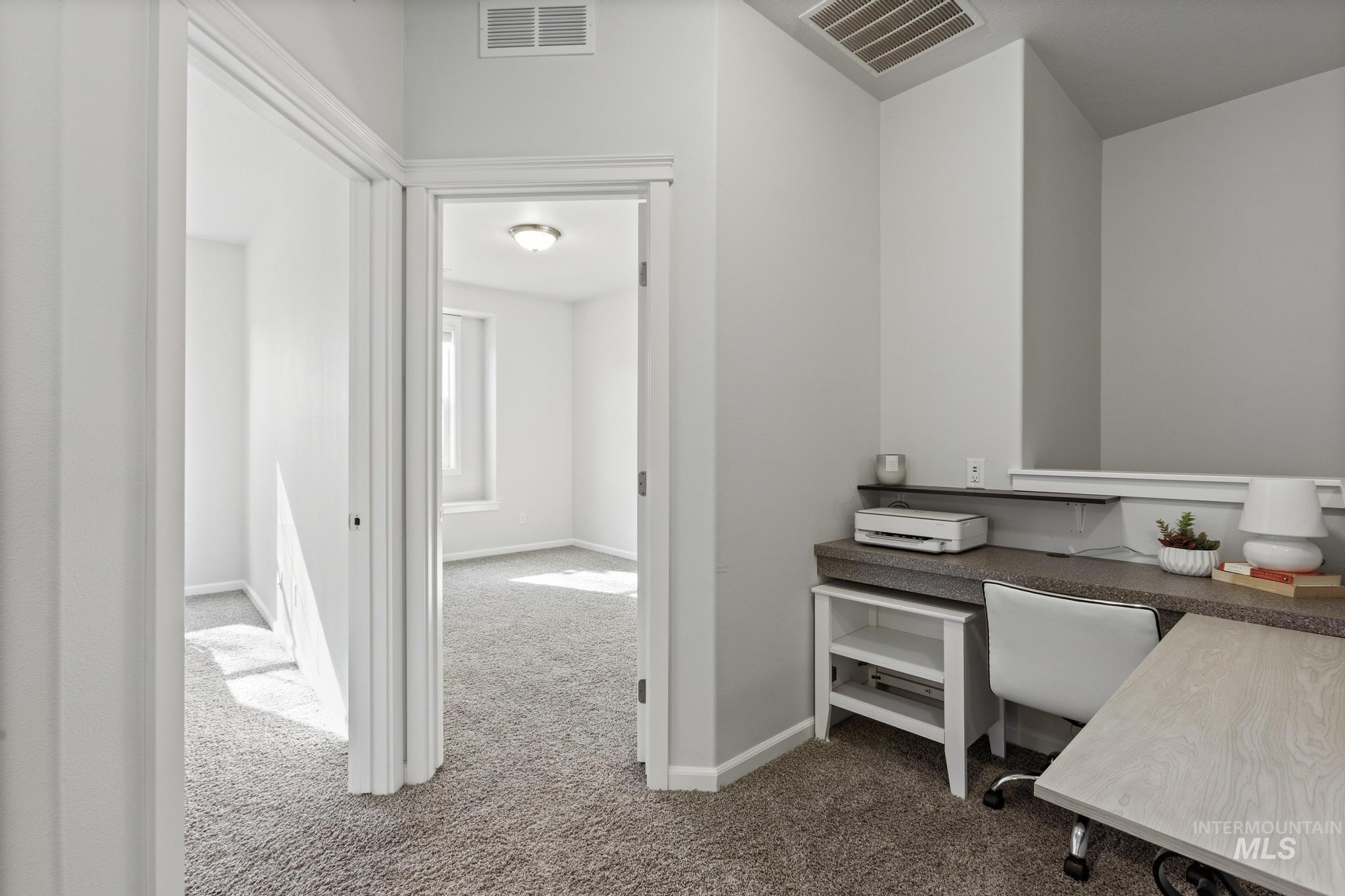 Office space featuring dark carpet and baseboards