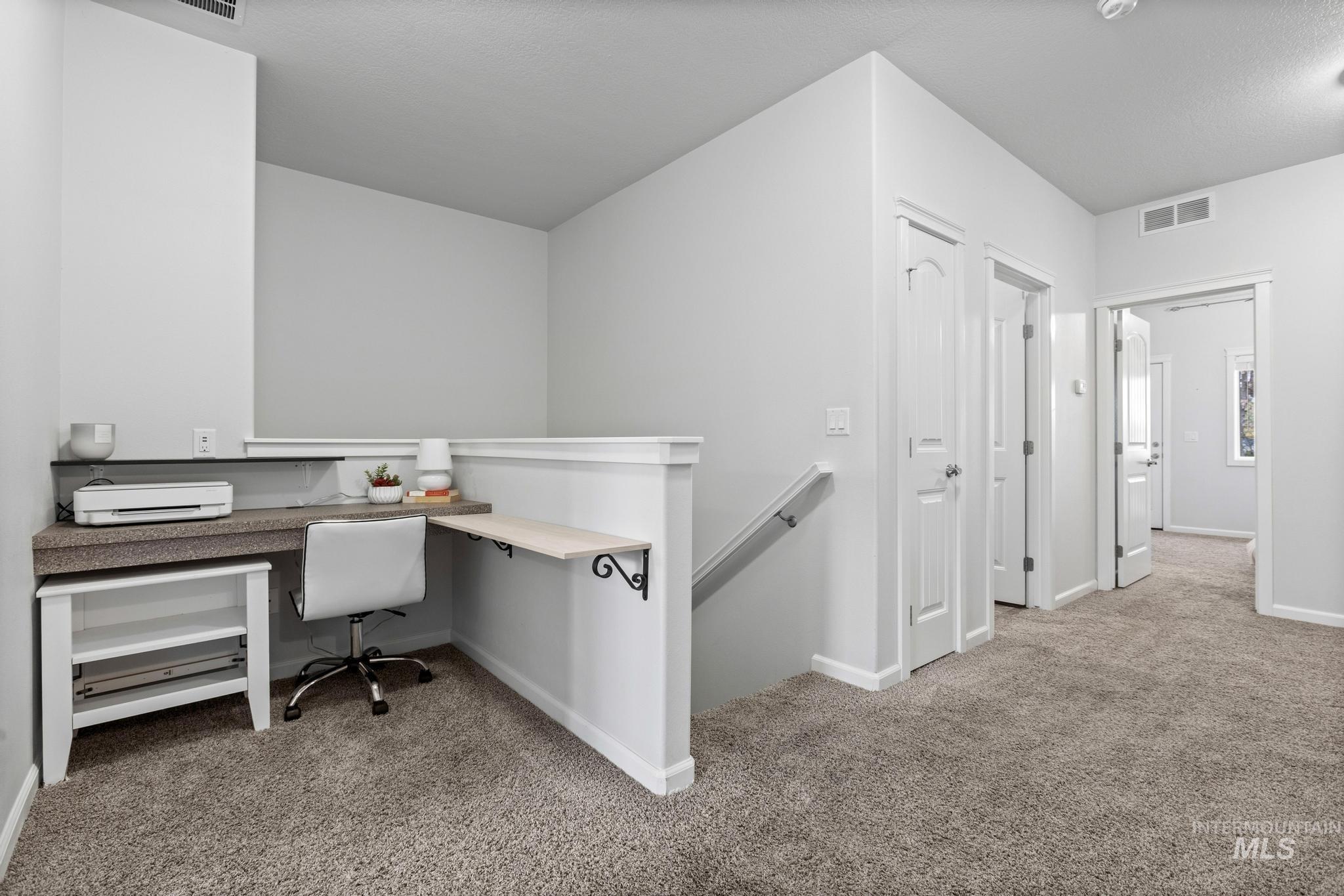 Office with light carpet and baseboards