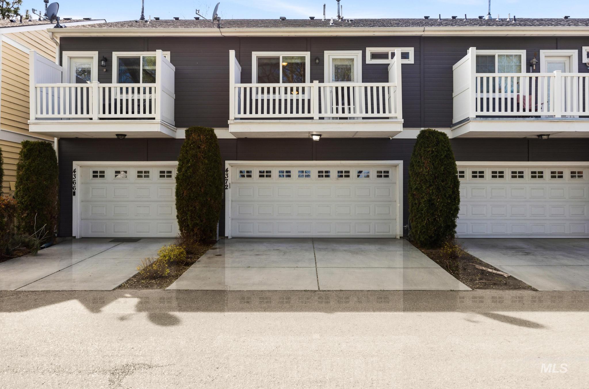 View of front facade featuring a balcony, a garage, and driveway