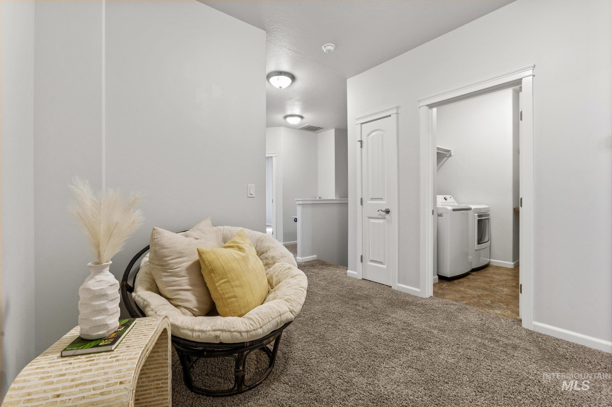 Living area with carpet and washer and dryer