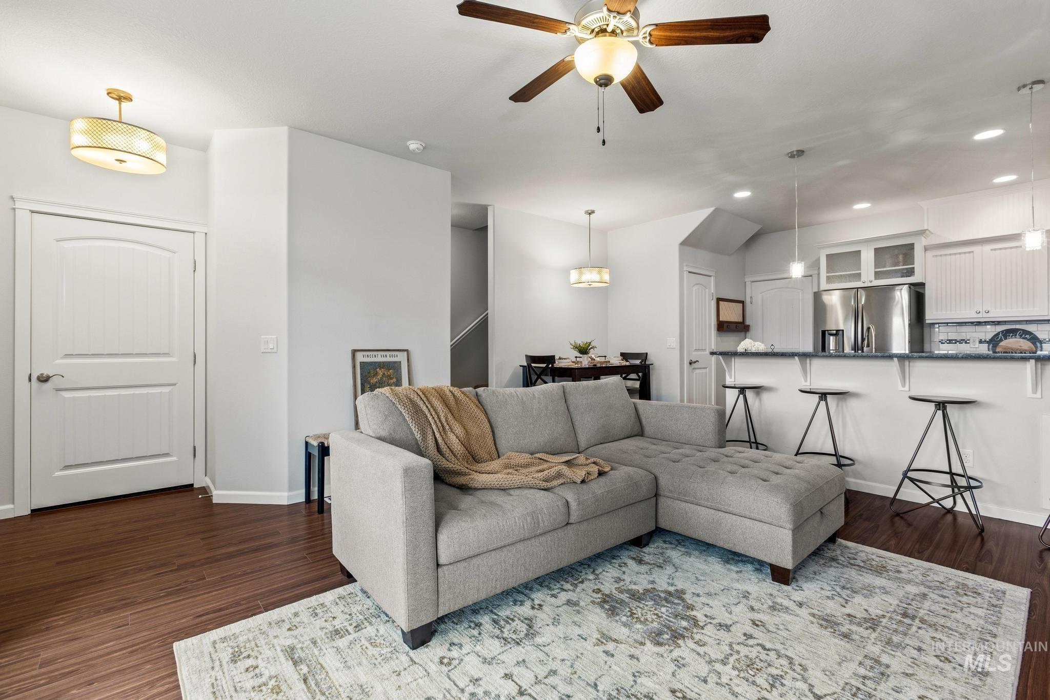 Living room featuring a ceiling fan, recessed lighting, and dark wood finished floors