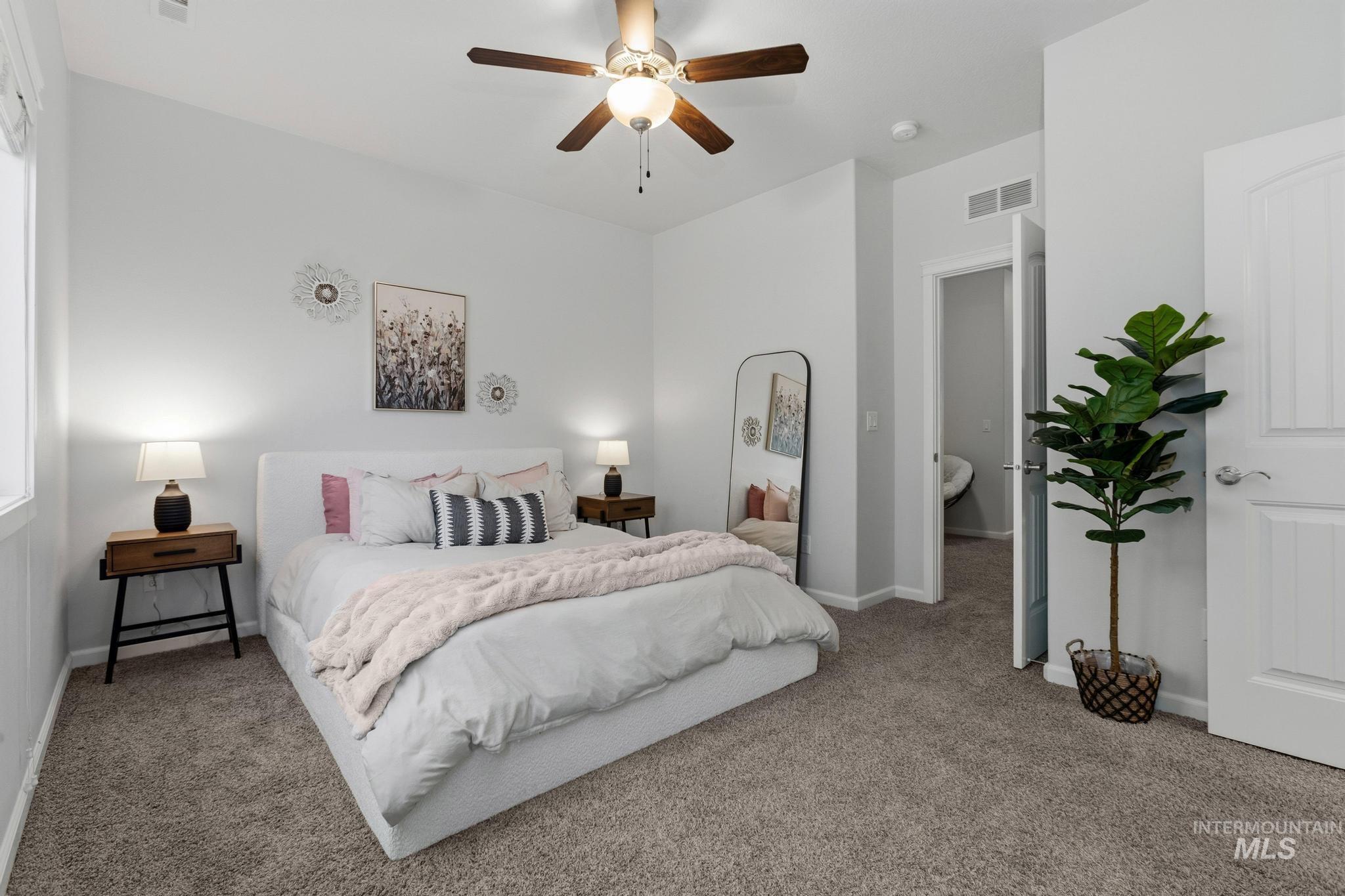 Carpeted bedroom with a ceiling fan and baseboards