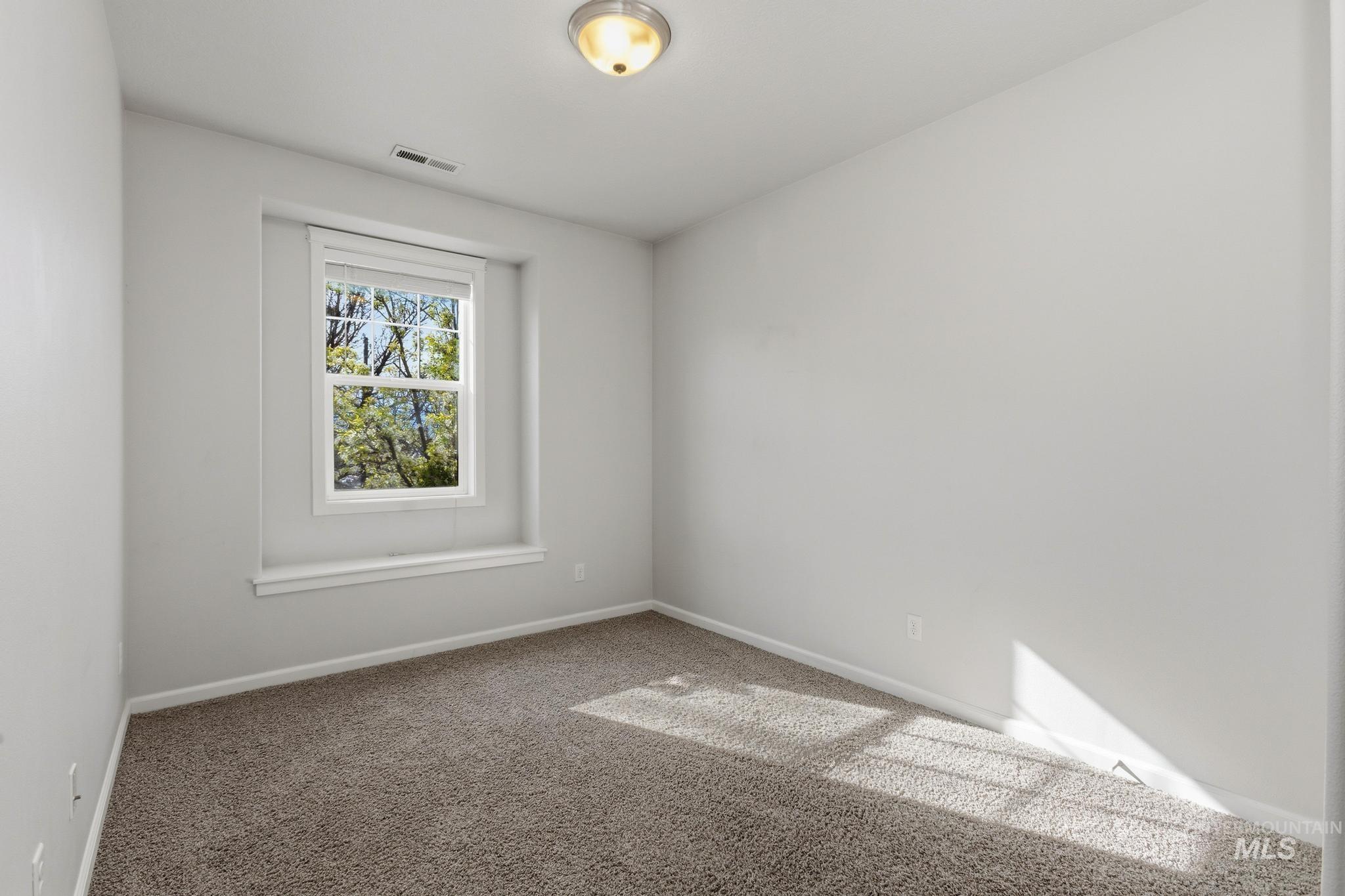 Carpeted empty room with baseboards