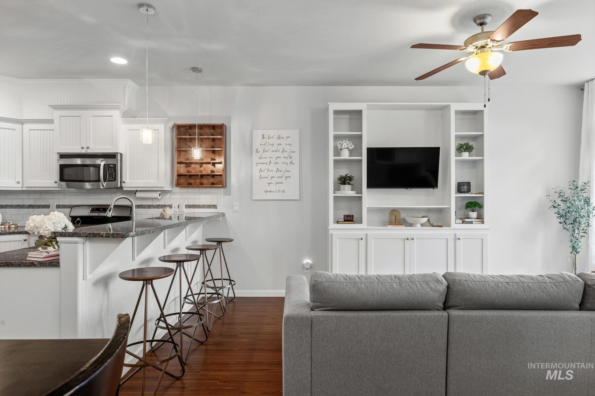 Living area featuring dark wood-style floors, a ceiling fan, and recessed lighting