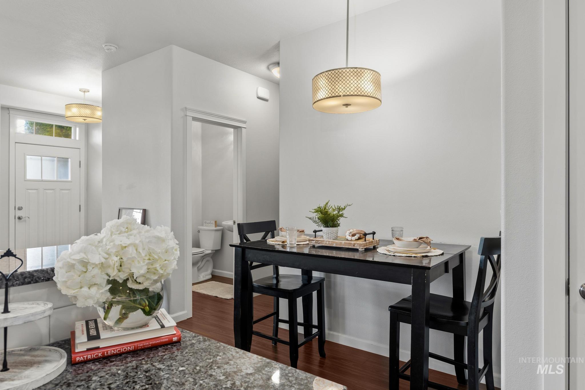 Dining space with dark wood-style floors and baseboards