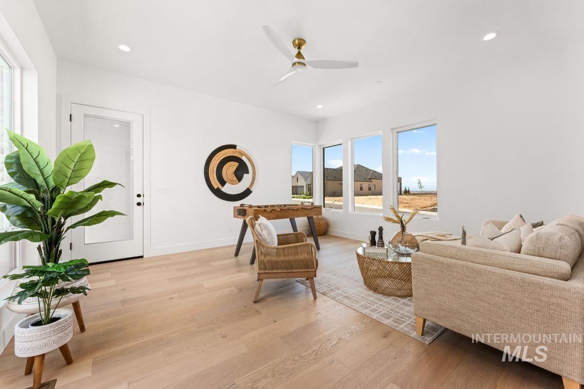 Bright living space featuring wood-finish flooring, recessed lighting, and a contemporary ceiling fan