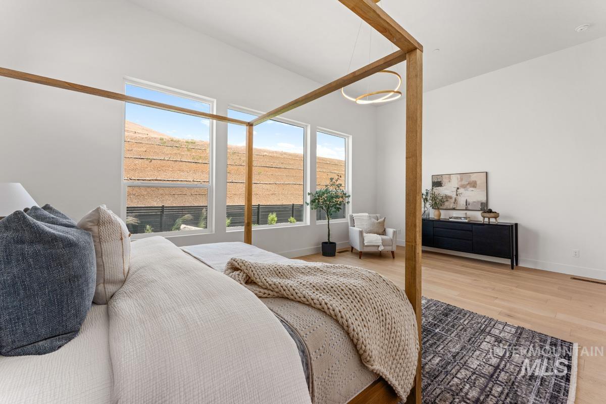 Bright room featuring expansive windows, high ceilings, wood-finish flooring, and a contemporary chandelier