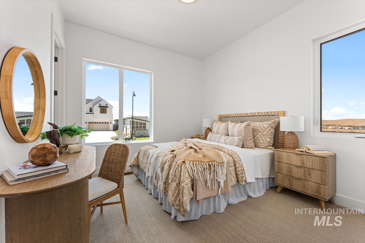 Bright room featuring expansive windows, neutral wall tones, and a light-toned carpet