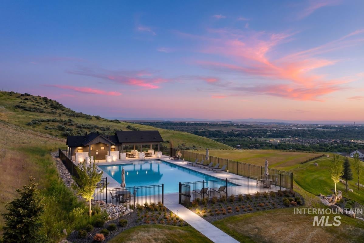 Outdoor swimming pool with surrounding patio, integrated lounge areas, and a covered pavilion