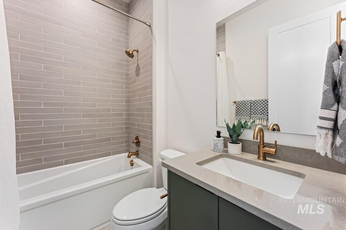 Bathroom featuring a tub/shower combination with horizontal subway tile surround, a built-in vanity with a single basin sink, and brass fixtures