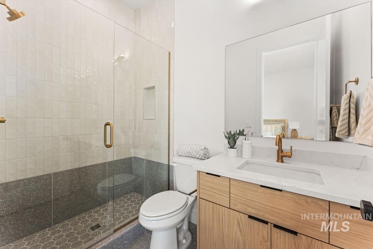 Bathroom featuring a glass-enclosed shower with honeycomb tile flooring and an integrated niche