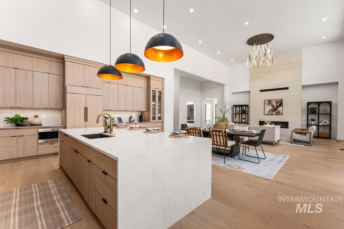 Spacious open-concept interior featuring light wood-finish flooring, high ceilings, and recessed lighting