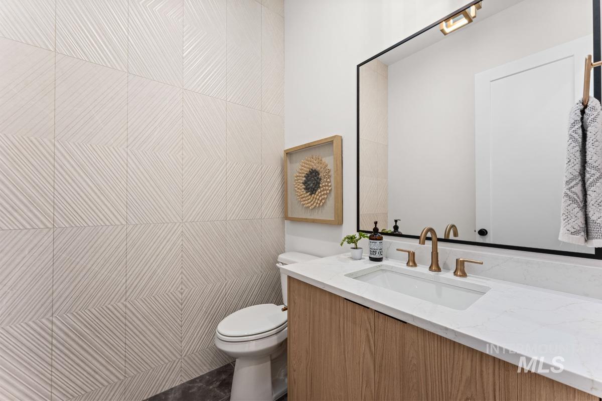 Modern vanity featuring a wood-finish cabinet, integrated rectangular sink, and bronze-toned faucet